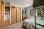 This cozy bedroom features a convenient built-in closet with sliding doors and open shelving for storage and display.