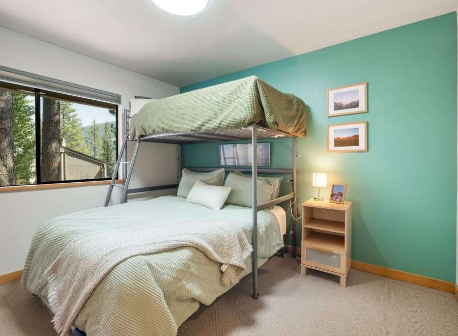 This charming bedroom features a space-saving bunk bed with a lower full-size bed and an upper twin-size bed, perfect for families or guests.