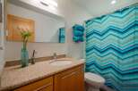 This modern bathroom features a sleek vanity with a granite countertop and ample storage.