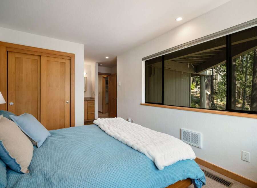 This inviting bedroom features a comfortable bed with blue and tan pillows, perfect for a restful night's sleep.
