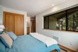 This inviting bedroom features a comfortable bed with blue and tan pillows, perfect for a restful night's sleep.