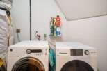This laundry room features two modern GE appliances, a washer and a dryer, side-by-side for efficient chore management.