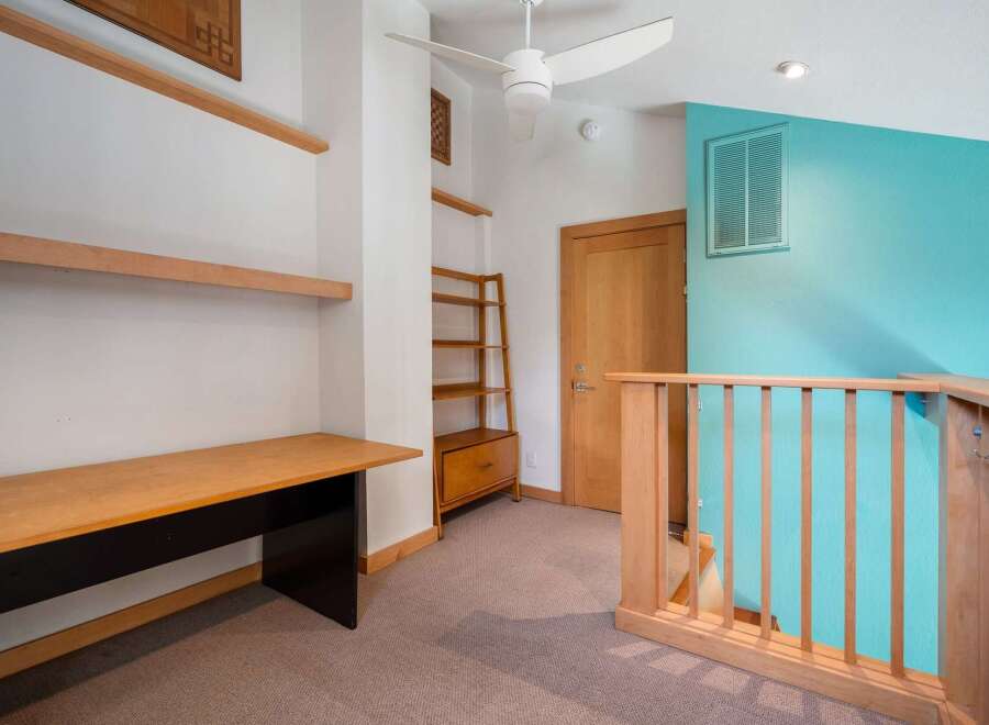 Discover a versatile loft space featuring a built-in desk and shelving, perfect for a home office or creative studio.
