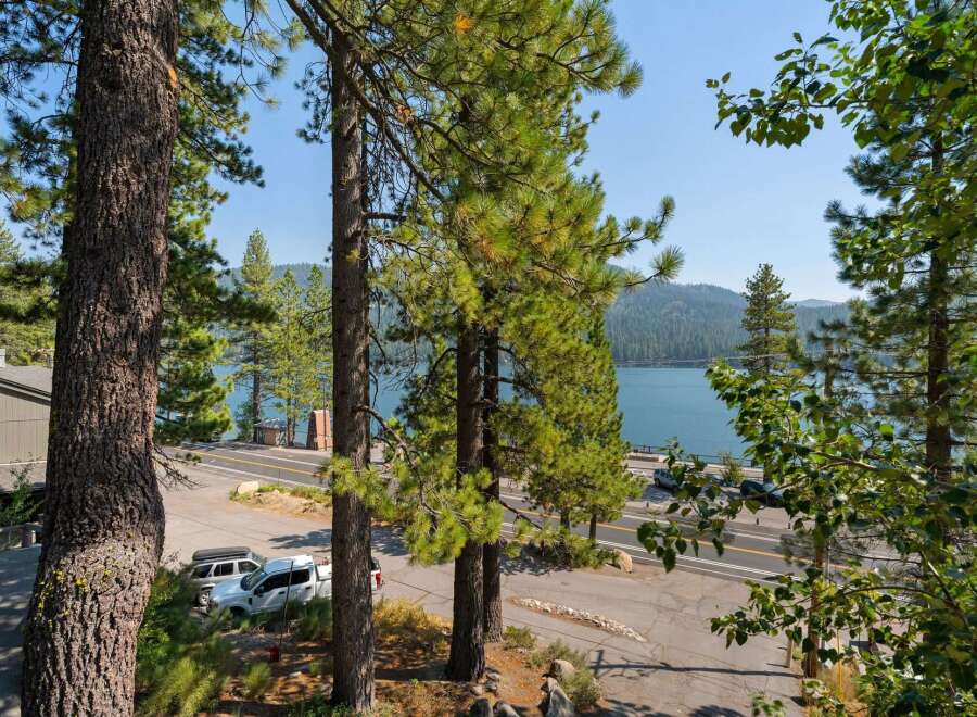 Experience breathtaking lake views from this stunning property, nestled amidst towering pine trees.