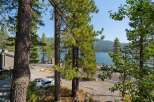 Experience breathtaking lake views from this stunning property, nestled amidst towering pine trees.