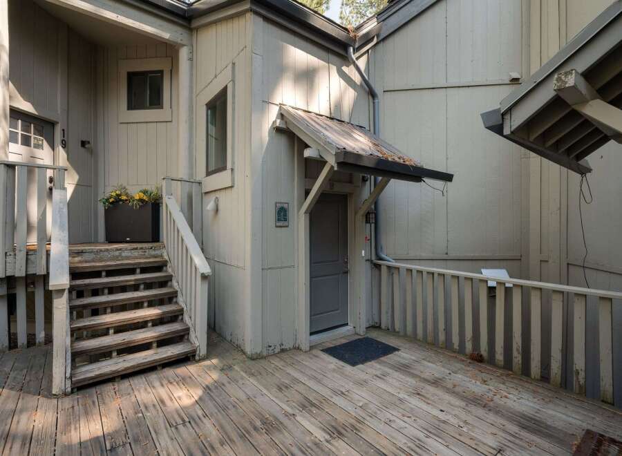 Discover this charming property featuring a welcoming wooden deck and a sturdy staircase leading to the entrance.