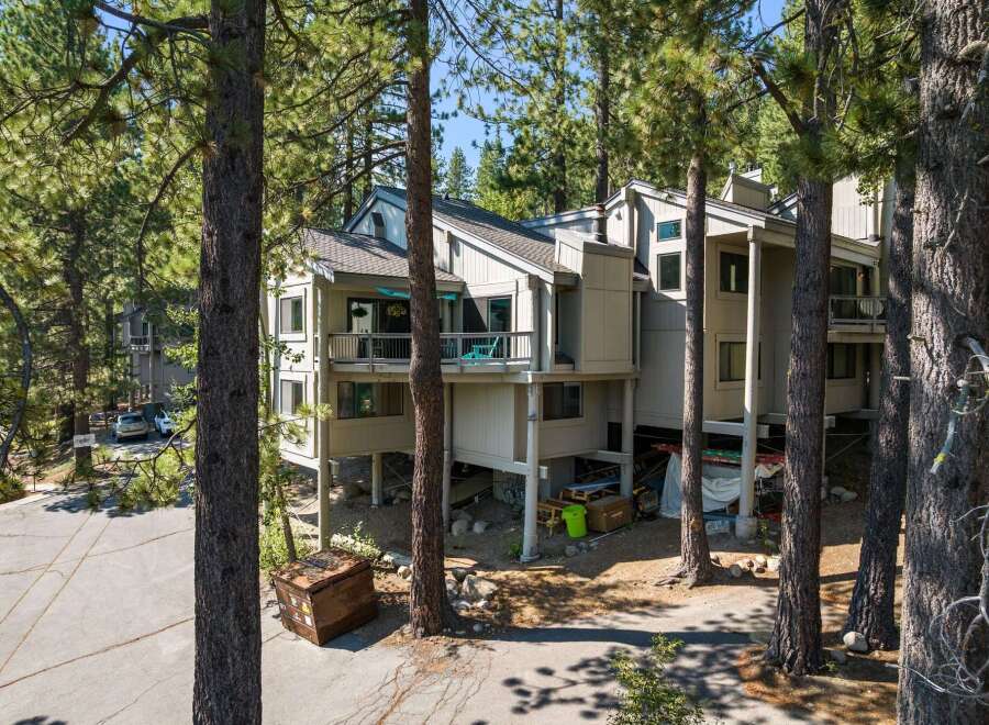 Nestled amongst tall pine trees, this multi-level home offers a unique living experience with its elevated structure and spacious balconies.