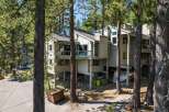 Nestled amongst tall pine trees, this multi-level home offers a unique living experience with its elevated structure and spacious balconies.