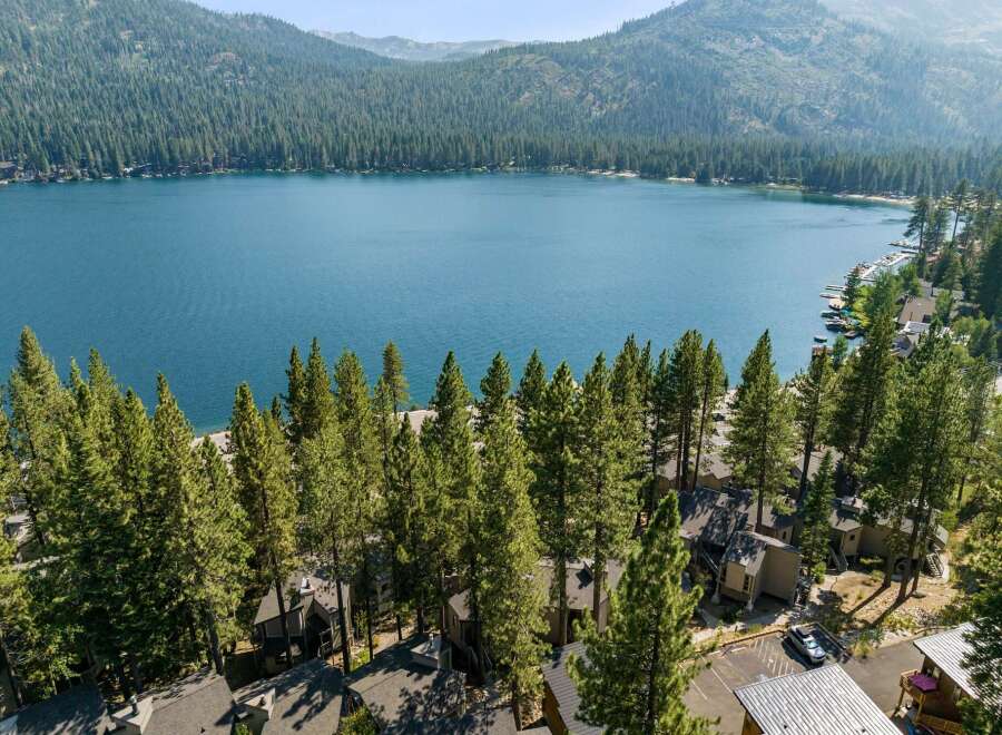 Experience the ultimate lakeside living with this stunning property offering breathtaking views of the crystal-clear blue water and surrounding lush green mountains.