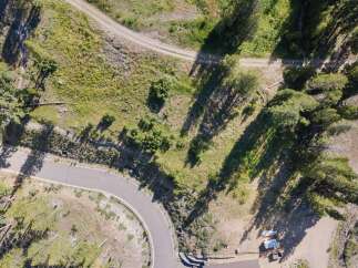 Discover this stunning aerial view of a property nestled amongst mature trees and natural landscape.