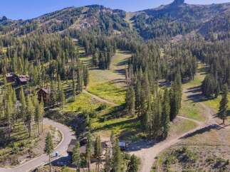 Nestled amidst a lush pine forest, this property offers a serene mountain retreat with stunning views of ski slopes and rugged peaks.