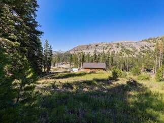 Nestled amidst a serene mountain landscape, this property offers a charming wooden cabin with a spacious yard.