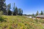Discover this picturesque property nestled amidst tall pine trees and lush green meadows, offering a serene and private setting.
