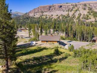 Nestled amidst a serene mountain landscape, this charming wooden home offers a tranquil retreat.