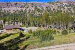 Nestled amidst towering pine trees and a majestic mountain backdrop, this property offers a serene escape.