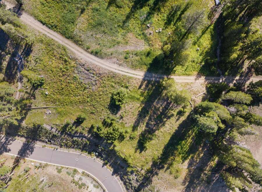 Discover this stunning property with a winding paved road leading to a secluded dirt path, perfect for outdoor adventures.