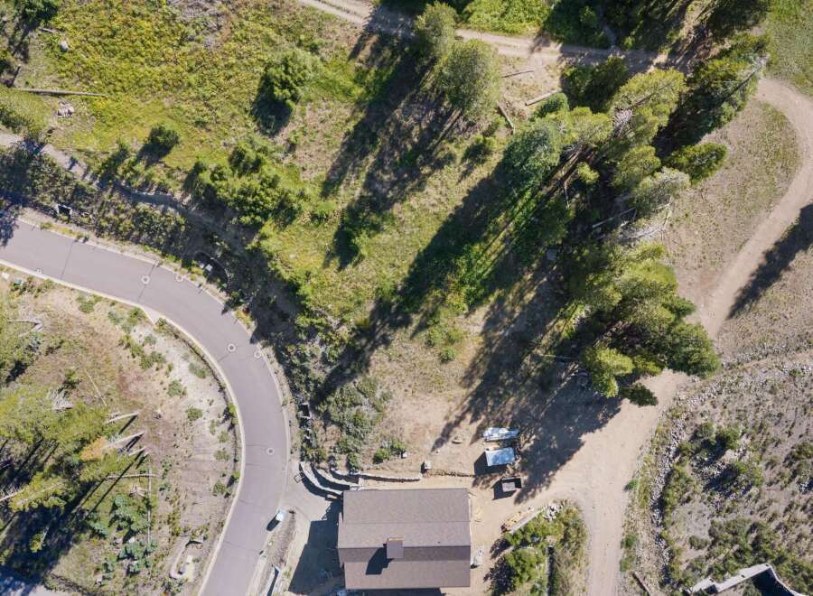 Discover this stunning aerial view of a property nestled amidst lush greenery and mature trees.