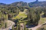 Nestled amidst a dense pine forest, this property offers a serene mountain retreat with stunning views of a ski slope and rugged peaks.
