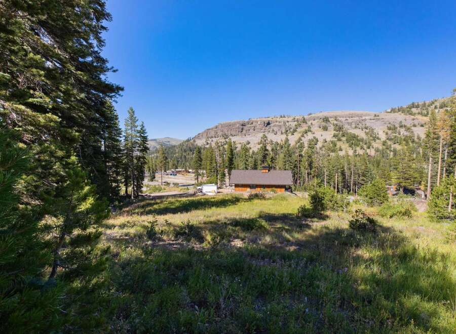 Nestled amidst a serene mountain landscape, this property offers a charming wooden cabin with a spacious yard.