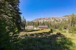 Nestled amidst a serene mountain landscape, this property offers a charming wooden cabin with a spacious yard.