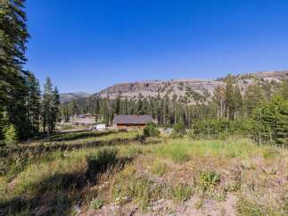 Nestled amidst towering pine trees and rolling meadows, this property offers a serene mountain escape.