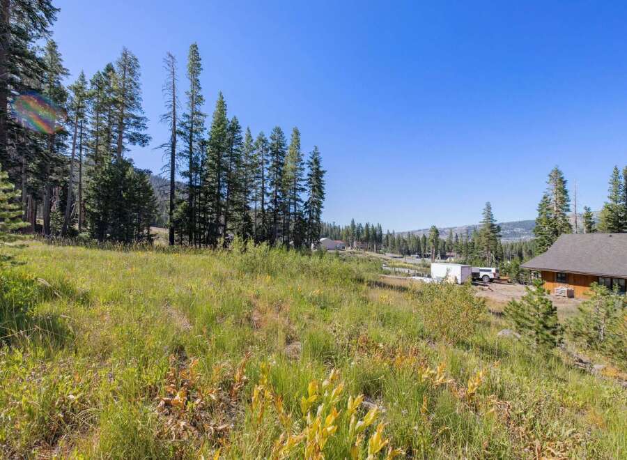 Discover this picturesque property nestled amidst tall pine trees and lush green meadows, offering a serene and private setting.
