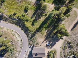 Discover this stunning aerial view of a property nestled amidst lush greenery and mature trees.