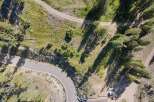 Discover this stunning aerial view of a property nestled amongst mature trees and natural landscape.