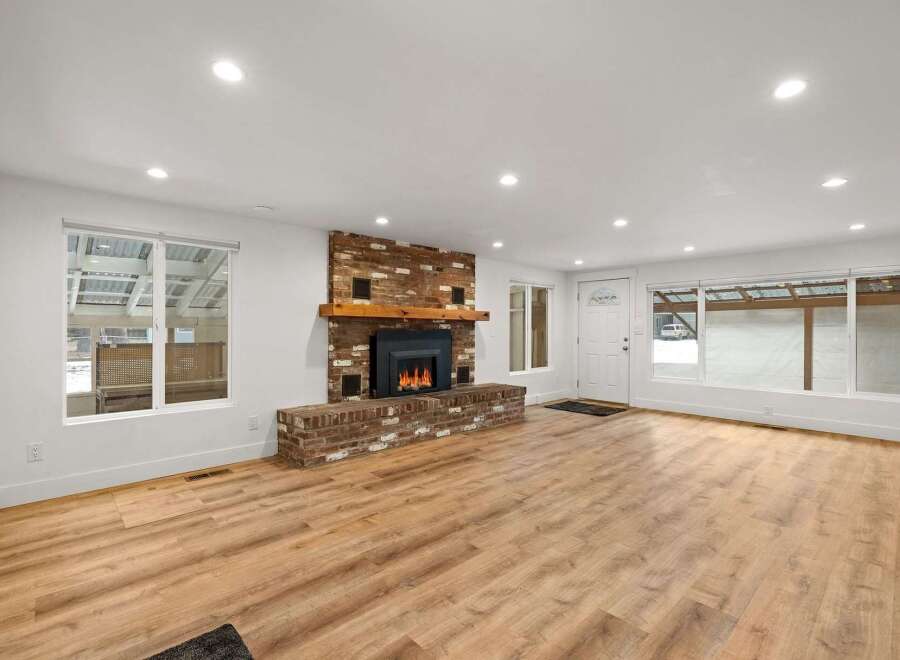 Experience cozy living in this beautifully renovated home featuring a stunning brick fireplace as the centerpiece of the spacious living area.