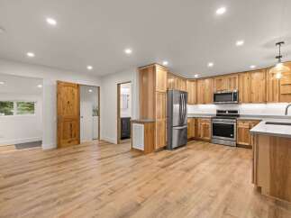 Discover this beautifully renovated kitchen featuring warm, natural wood cabinetry and sleek stainless steel appliances.