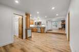 Discover this beautifully renovated home featuring a modern kitchen with ample wood cabinetry and stainless steel appliances, seamlessly flowing into a spacious living area.