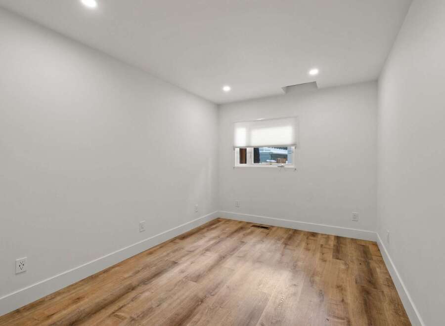 Discover this bright and airy room featuring pristine white walls and a modern wood-look floor.