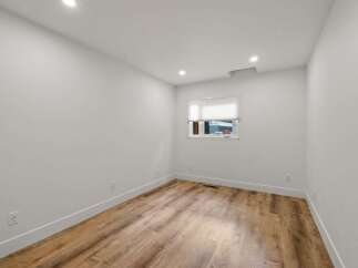 Discover this bright and airy room featuring pristine white walls and a modern wood-look floor.