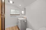 This bright and airy bathroom features a modern gray vanity with a white countertop and a sleek chrome faucet.