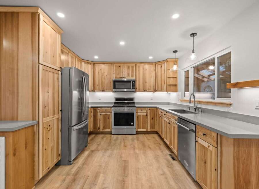 Experience the warmth and natural beauty of this stunning kitchen, featuring custom knotty wood cabinetry that adds rustic charm.