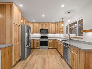 Experience the warmth and natural beauty of this stunning kitchen, featuring custom knotty wood cabinetry that adds rustic charm.