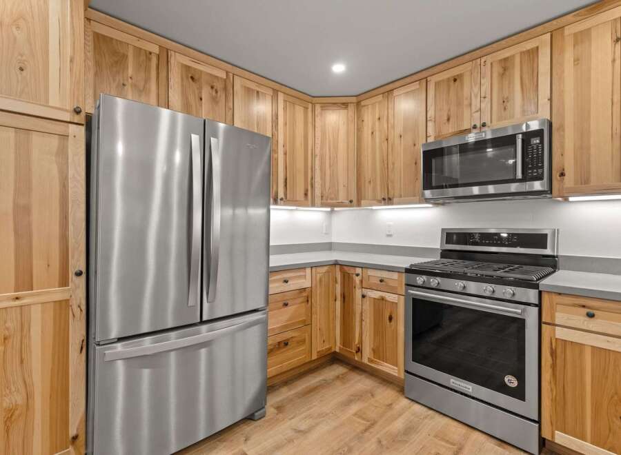 Discover this beautifully appointed kitchen featuring sleek stainless steel appliances, including a French door refrigerator and a modern gas range.