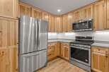 Discover this beautifully appointed kitchen featuring sleek stainless steel appliances, including a French door refrigerator and a modern gas range.