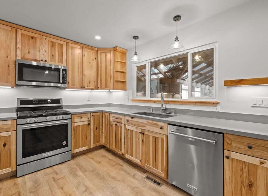 Experience the warmth and natural beauty of this stunning kitchen, featuring custom knotty wood cabinetry that adds rustic charm.