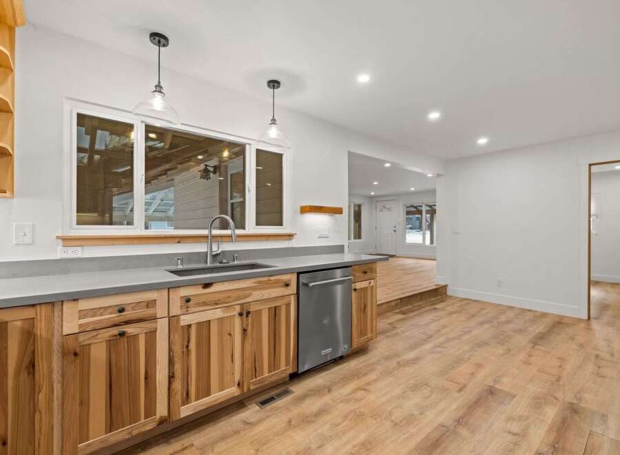 Discover this beautifully renovated kitchen featuring custom natural wood cabinetry and sleek concrete countertops.