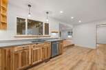 Discover this beautifully renovated kitchen featuring custom natural wood cabinetry and sleek concrete countertops.