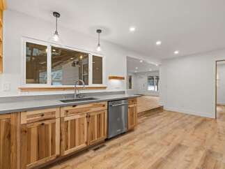 Discover this beautifully renovated kitchen featuring custom natural wood cabinetry and sleek concrete countertops.