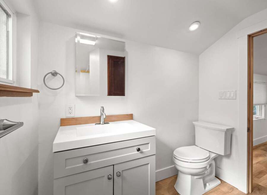 This modern bathroom features a sleek vanity with ample storage and a clean white countertop.