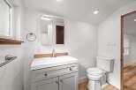 This modern bathroom features a sleek vanity with ample storage and a clean white countertop.