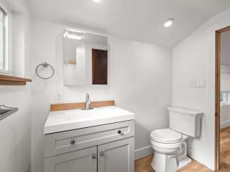 This modern bathroom features a sleek vanity with ample storage and a clean white countertop.