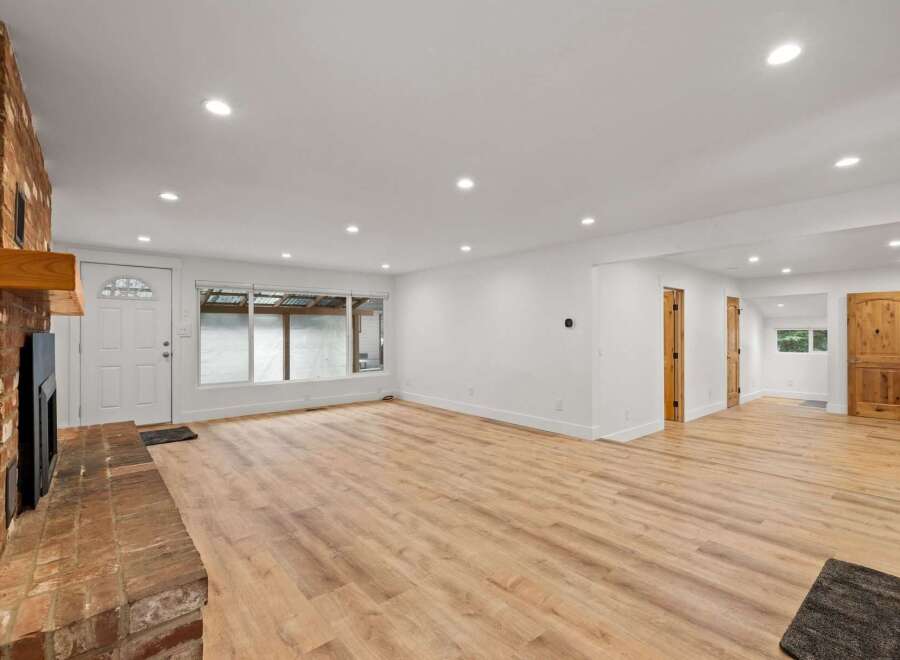 Step into this beautifully renovated living space featuring a stunning brick fireplace and a large picture window that floods the room with natural light.
