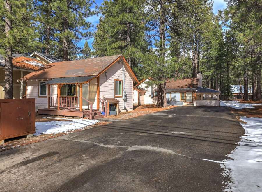 Nestled among tall pine trees, this charming property offers a serene retreat.