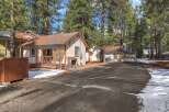 Nestled among tall pine trees, this charming property offers a serene retreat.