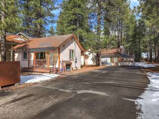 Nestled among tall pine trees, this charming property offers a serene retreat.