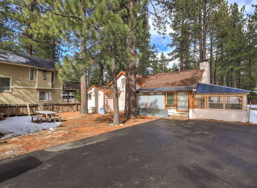 Nestled among tall pine trees, this charming property offers a serene retreat.